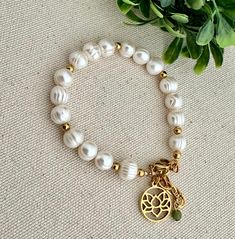 The combination of simplicity and sophistication makes this bracelet an elegant jewel of natural beauty. The lotus flower charm represents the path to spiritual renewal and enlightenment and the pearls inspire purity and peace. Freshwater pearls and 18k gold over steel accessories. Adjustable from 5.5" to 7.5" All jewelry is handmade to order in our Port Richey, Fl studio by owner and designer, Soledad. Please allow me 1-3 business days to make and package your piece(s). Your items are expected Spiritual Pearl Bracelet With Pearl Charm, Spiritual Pearl Bracelet With Charm, Spiritual Pearl Bracelet With 8mm Beads, Spiritual 8mm Pearl Beads Bracelet, Spiritual Pearl Bracelet, Elegant 8mm Beads Bracelet For Meditation, Spiritual Beaded Bracelets With Pearl Charm, Spiritual Pearl Bracelet With Pearl Charm As Gift, Spiritual Pearl Bracelet With Charm As Gift