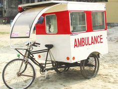 a bike parked next to an ambulance with a trailer on it's back tire