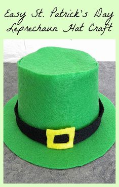 a green hat with black band and yellow buckle on the side, sitting on top of a cement surface