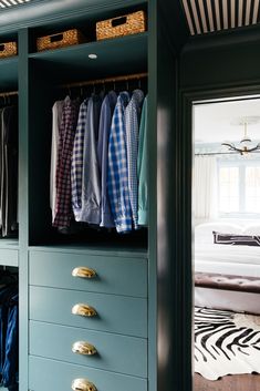 an open closet with clothes hanging on it