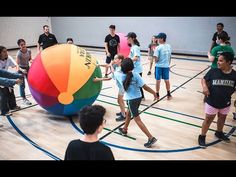 a group of people standing around a colorful ball