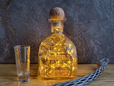 a lighted bottle next to a glass on a table