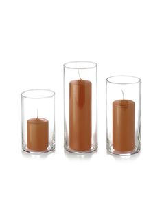 three candles are sitting in glass vases