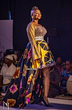 a woman in a colorful dress standing on a stage