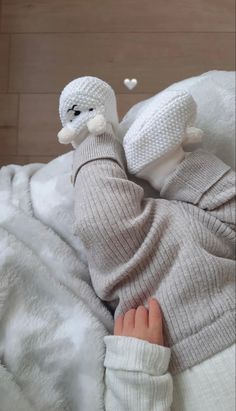 a baby is laying down on a blanket with a stuffed animal in it's arms