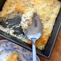 a close up of a spoon in a casserole on a plate with another dish