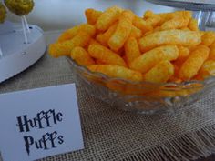 a glass bowl filled with cheetos next to a sign that says harry potter