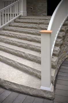 a white stair case sitting on top of stone steps