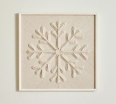 a white wall hanging with a snowflake design on it