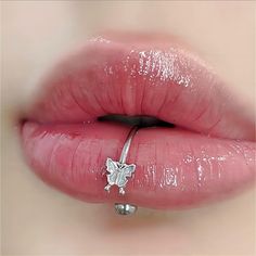 a woman's lips with a silver nose ring on top of her lip,