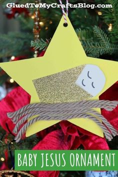 a star ornament hanging from a christmas tree with the words baby jesus on it