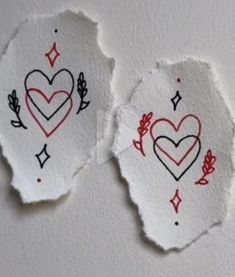 two torn pieces of paper with hearts drawn on them