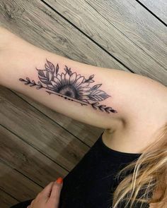 a woman with a sunflower tattoo on her arm