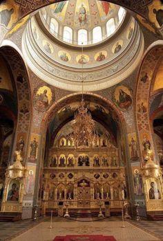 the inside of a church with many paintings on it's walls and an ornate alter