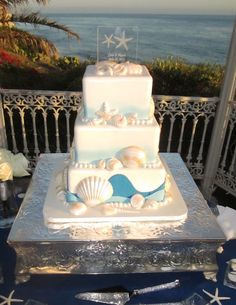 a wedding cake with seashells on it and the caption is in english