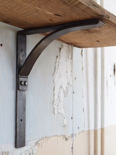 an old wooden shelf with metal brackets on it