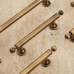 six brass handles on the back of a marble counter top with gold colored knobs