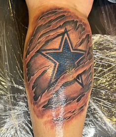 a man's leg with a tattoo on it that has an image of a star