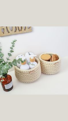 two baskets with cookies in them sitting next to a potted plant and bottle of honey