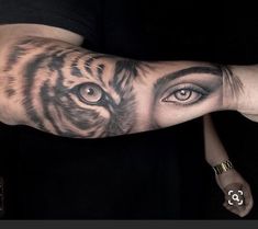 a man's arm with a tiger tattoo on it and an eye in the middle