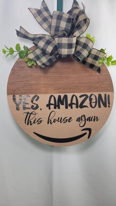 a wooden sign that says yes amazon this house is open with a bow on it