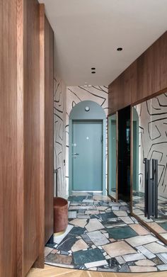 a hallway with tiled floors and wooden walls, leading to a blue door in the center