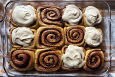 cinnamon rolls with cream cheese frosting in a glass baking dish