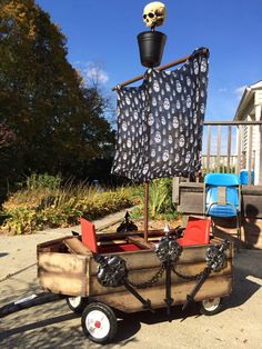 a wooden wagon with a skull on top and a pirate flag hanging from the back