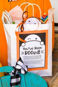 an orange and white bag sitting on top of a wooden table next to a pumpkin