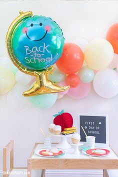 a back to school party with balloons and desserts