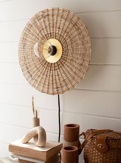 a wicker fan sitting on top of a table next to vases and other items