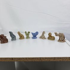 small ceramic figurines are lined up on a table