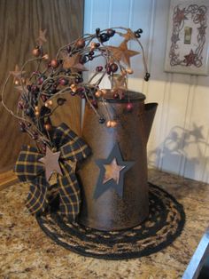 a pot with some decorations on top of it sitting on a counter next to a candle holder