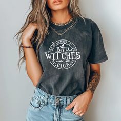 Cute Halloween Bad Witches Club T-Shirt, Vintage Comfort Colors Witch Shirt Join the "Bad Witches Club" and wear you mischief with pride this halloween season! Our hilarious t-shirt is perfect for all the sassy witches out there who love to embrace their fun, rebellious side. Whether you're brewing potions or casting spells, this tee is your new go-to for showcasing your wicked sense of humor! Made with Comfort Colors 1717 cozy 100% ethically grown and harvested pre-shrunk cotton. The soft-washed durable fabric brings extra coziness to your wardrobe while the relaxed fit makes it an excellent daily choice. This t-shirt is perfect for everyday wear or for lounging around the house.   ✨See Photos For Details. ✨Select your tee shirt size and color in the drop down menus next to the item photo Hocus Pocus Shirt, Casting Spells, New Aunt, People Talking, The Worst Witch, Club T Shirt, Festive Wear, Retro Halloween, Fun Design