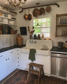 a kitchen with an oven, dishwasher, sink and other items hanging on the wall