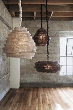 three lights hanging from the ceiling in an empty room with wood floors and exposed ceilings