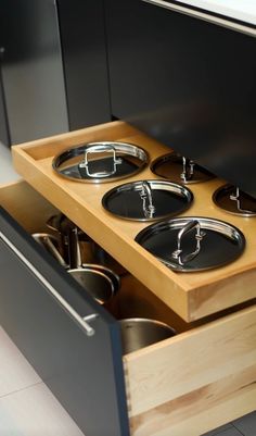 an open drawer with pots and pans in it