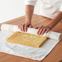 a person rolling out some bread on top of a table