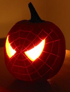 a spiderman pumpkin with its eyes glowing