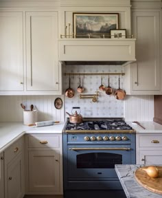 a kitchen with white cabinets and blue stove