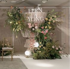 a floral display in the middle of a room with chairs and flowers on the floor