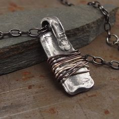 Cette Amulette "Warding Off" est finement fabriquée en argent sterling 925 pour créer un bijou accrocheur et protecteur.
Une patine foncée est appliquée puis un fil traité à la flamme par un procédé spécial est enroulé autour de l'amulette pour éloigner tout mauvais esprit ou énergie négative.
Ce talisman unique et insolite est le cadeau parfait pour montrer à vos proches à quel point vous vous souciez d'eux. Handmade Silver Copper Necklace, Oxidized Rectangular Pendant Necklace, Unique Necklace With Rectangular Oxidized Pendant, Unique Necklace With Oxidized Rectangular Pendant, Unique Silver Necklaces With Copper Material, Unique Necklace With Oxidized Finish And Rectangular Pendant, Unique Oxidized Necklace With Rectangular Pendant, Silver Hand Wrapped Metal Necklace, Silver Copper Jewelry Hand Forged