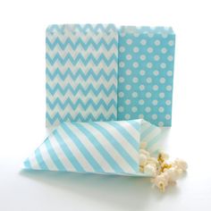 popcorn bags with blue and white chevrons are sitting next to each other on a table