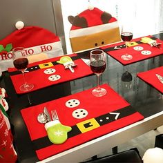 the table is set with red placemats and silverware for christmas dinner guests