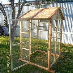 a small wooden chicken coop sitting in the grass