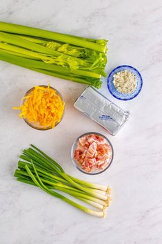 celery, carrots, cheese and other ingredients on a white counter top