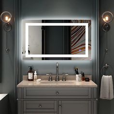 a bathroom vanity with a large mirror above it and lights on either side of the sink