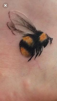 a small bee tattoo on the foot