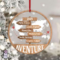 a wooden ornament hanging from a christmas tree with the names of destinations on it