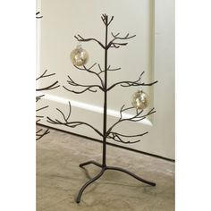 a metal christmas tree with three ornaments on it's branches and two balls hanging from the top